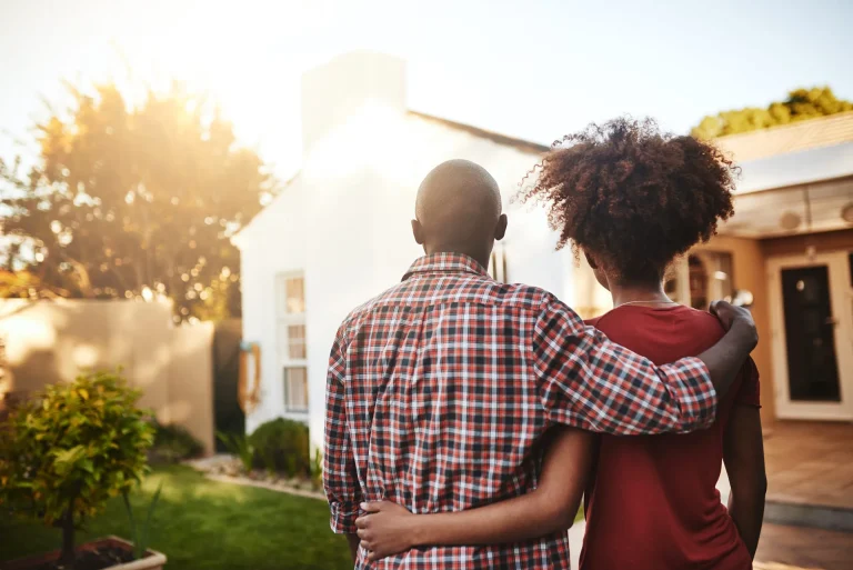 Couple souriant déménageant, représentant le rachat de crédit immobilier avec Starteo Courtage Toulouse
